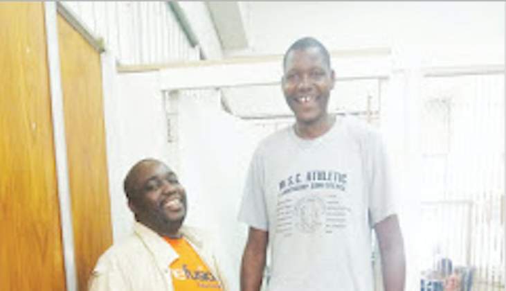 Simbarashe Mhukahuru, probably Zimbabwe's tallest man at 2,11m turned heads when he walked through the streets of Masvingo on Tuesday. Above The Mirror editor Nkulumani Mlambo looks like a midget when he stands besides Mhukahuru whose head is above the door way.