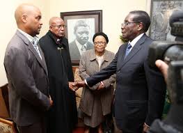 President Mugabe consoles Bishop Peter Hatendi , Kule Chitepo (far left)