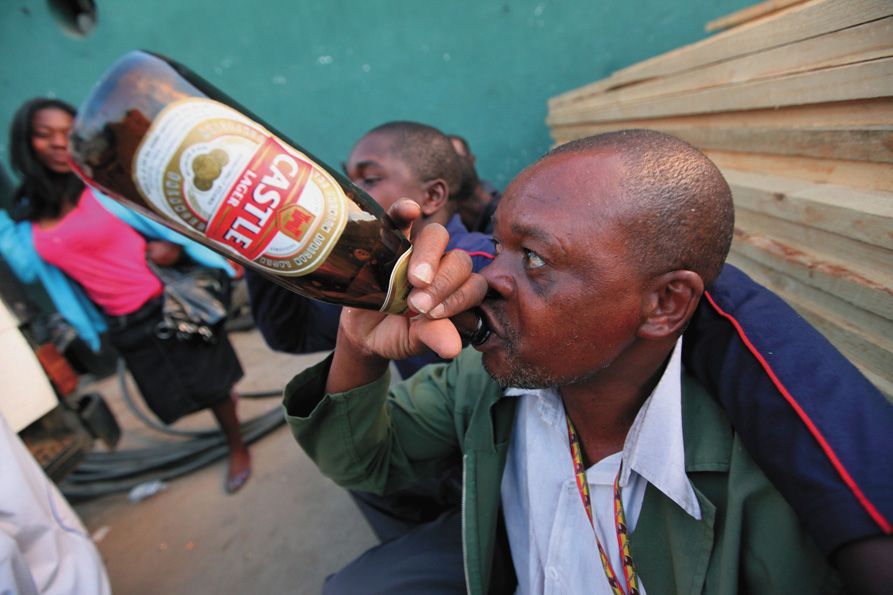 BEER SALES SURGE—A man drinks a beer in Harare