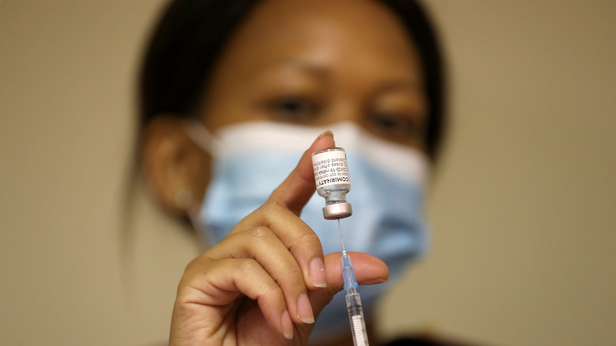 A health worker holds a vial of the Pfizer/BioNTech COVID vaccine. File pic